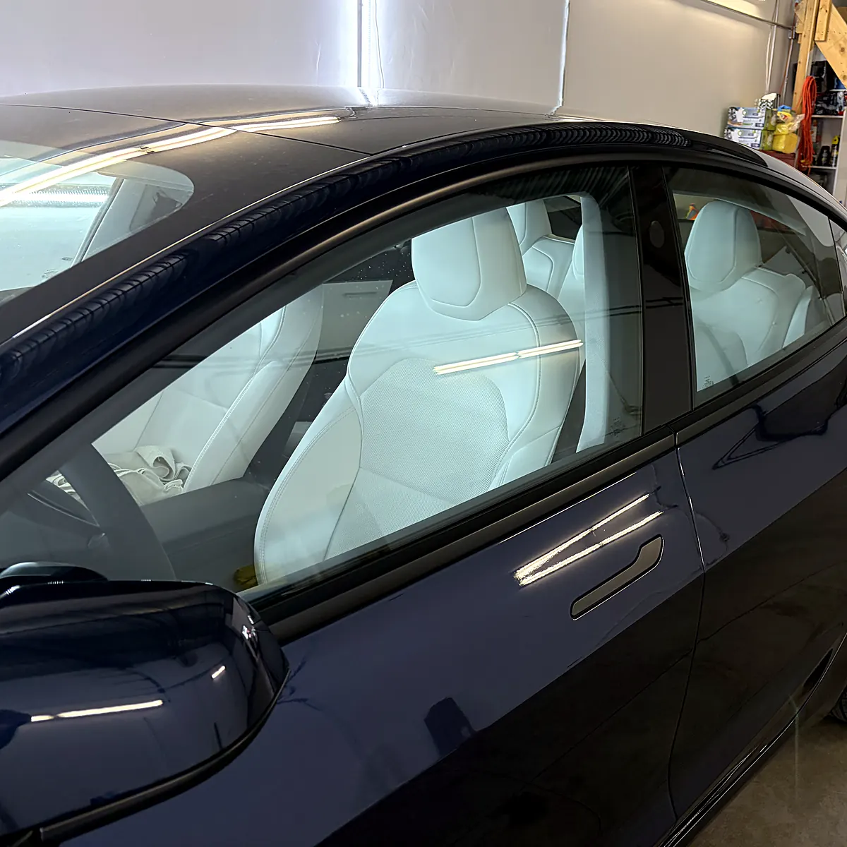 Vitres latérales d’une Tesla Model 3 avant le teintage, verre d’origine laissant voir l’intérieur blanc, au studio Wrap Senators à Ottawa